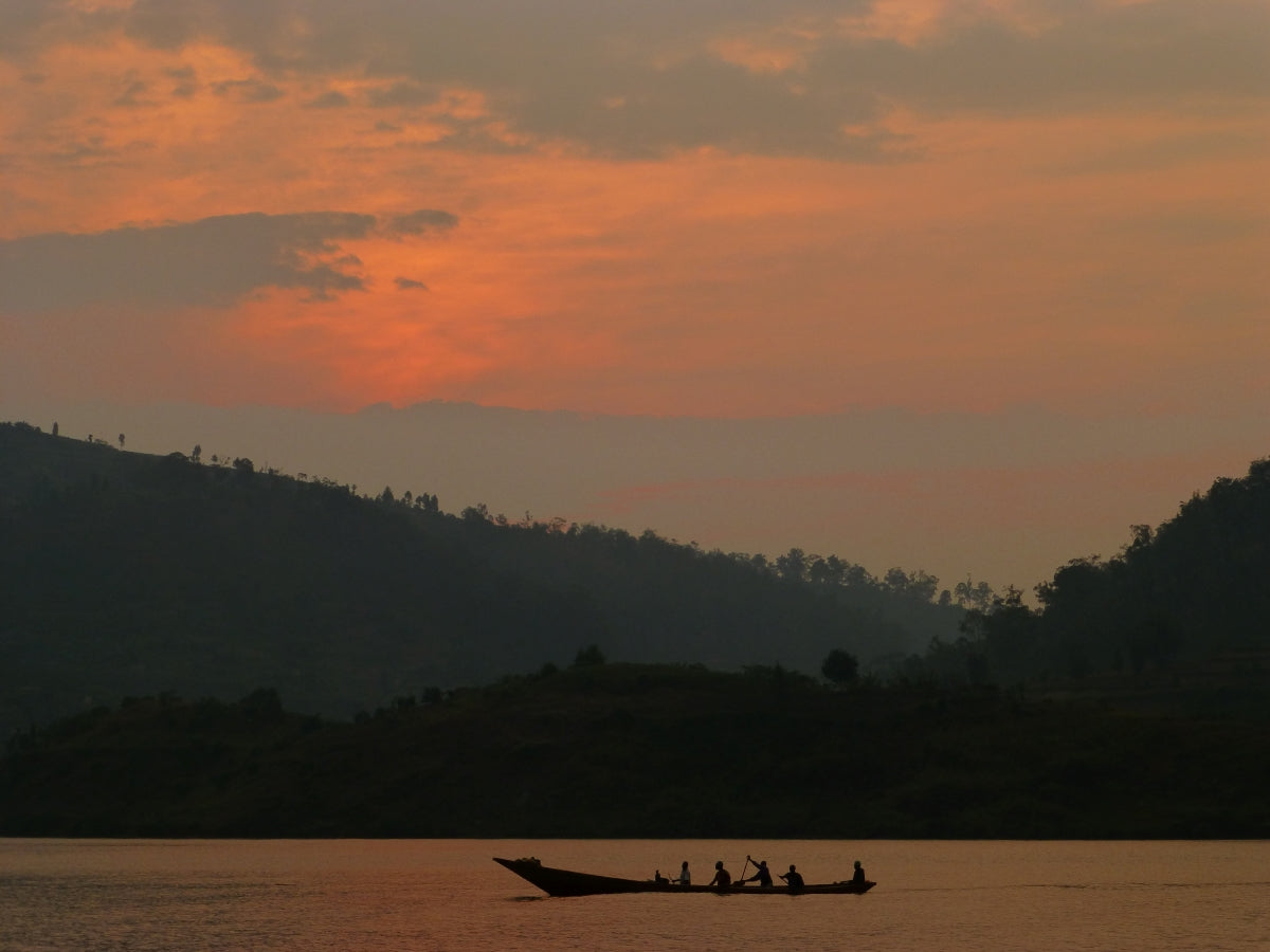 Fishermen row across Lake Kivu at sunrise off the peninsula of Kumbya, Rwanda