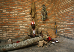A man uses a tool to carve a tree trunk